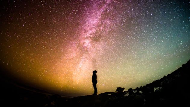 Man looking up at the infinite night sky